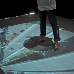 Modélisation intuitive de la ville 2.0 / 2008 / ordinateur, vidéoprojecteur, miroir de 1m2, filter vis-cut, lumière IR / vidéo projection au sol de 280 x 350 cm